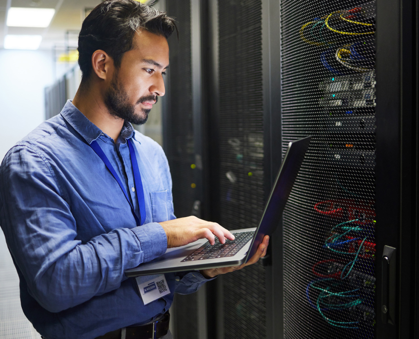 It Professional With Laptop In Data Center